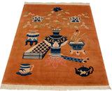 Copper vintage Peking rug with cobalt blue vase, blossoms, tea kettle, and tea cup.