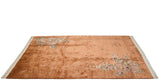 Close-up of the Art Deco carpet's lower right, featuring blush floral details and carved border.