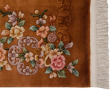 Carved dimensional florals on copper field of a Vintage Art Deco rug with beige fringe.