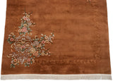 Fringe and sprawling foliage with dimensional carved border on an Art Deco copper rug.