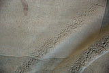 Close-up of the vintage Chinese carpet's hand-knotted foundation, showing tight knots and beige texture.