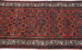 Close-up of vintage Persian Engelas runner, showcasing cherry red Herati and scrolling vine borders.
