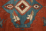Close-up of the bold diamond medallion in brick red and beige against the ocean blue field of the carpet.