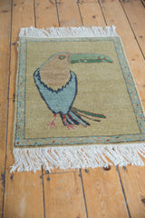 Corner view of the pictorial Armenian rug, showcasing powder blue vine border and white fringe.