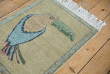 Green toucan beak, powder blue vine border, and white fringe on the Armenian rug.