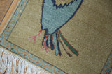 Pictorial Armenian Toucan rug's blue body, pink feet, vine border, and white fringe.