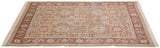 Angled perspective of a vintage Armenian rug with terra cotta palmettes on a sand-colored field.