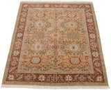 Angled view of a vintage Armenian Sultanabad carpet with floral palmettes and a terra cotta border.