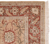 Corner of a vintage Armenian Sultanabad carpet showing the rust floral border and intact fringe.