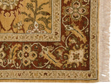 Corner detail of the Sultanabad design carpet showing the floral border in terra cotta and gold, and its cream fringe.