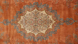 The sharp scalloped center medallion featuring a dense millefleur design against a pale terra cotta field.