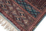 Corner detail of a fine Bokhara carpet showing the powder blue border, intact side cord, and original ivory fringe.