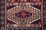 Tight weave and plush wool pile of a Bokhara gul medallion in red, blue, and ivory.