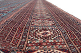 A lengthwise perspective of the repeating gul medallions on a fine vintage Bokhara carpet.