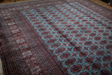 Corner perspective of a fine Bokhara carpet showing repeating guls and detailed geometric borders.