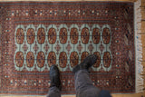 A perspective view showing the plush wool pile and detailed gul medallions of a fine Bokhara rug.