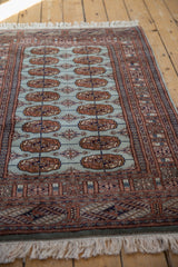 A view down the length of a vintage Bokhara rug, emphasizing its soft, lustrous pile.
