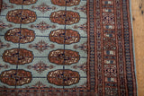Detailed corner of a fine Bokhara rug with plush wool pile and traditional gul motifs.