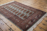 Angled perspective on a fine vintage Bokhara rug showing its lustrous pile and gul design.