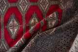 Draped vintage Turkmen rug with plush red pile, showing intricate geometric borders.