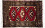 Vintage Pakistani Turkmen rug with cherry red field, geometric stepped diamond medallions, and dark borders.
