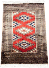 White fringe, cherry red diamond motifs, and intricate geometric borders of a Turkmen rug.