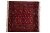 Vintage Bokhara square rug in cherry red with repeating gul medallions in dark navy blue and ivory.