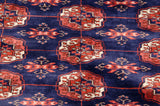 Lustrous sheen on the plush navy blue wool pile of a vintage Bokhara carpet with rust gul medallions.
