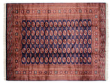 A vintage Bokhara carpet with rows of rust and ivory elephant's footprint medallions on a navy blue field.
