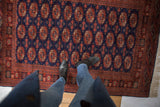 A view from above of the detailed gul medallions and plush navy wool pile.