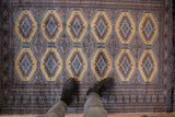 Stepped diamond gul medallions in mauve and sky blue on the dusty gold field of a vintage Pakistani rug.