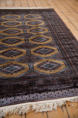 Side perspective of a Pakistani Turkmen rug's repeating diamond guls and intricate borders.