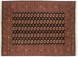 Hand-knotted vintage Bokhara carpet with black field, repeating terra cotta elephant footprint motifs, 9' x 12'2