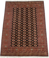 Geometric design of vintage Bokhara rug with terra cotta gul medallions and patterned borders.