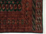 Intricate rust geometric border and clean ivory fringe on the corner of a vintage Bokhara carpet.