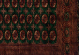 Intricate rust border beside the emerald green field of a vintage Bokhara carpet with repeating gul medallions.