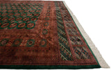 Angled view of a Bokhara carpet's lustrous pile, intricate rust border, and clean ivory fringe.