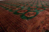 Angled view of the lustrous, plush wool pile on a vintage emerald green and rust Bokhara rug.