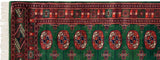 Plush emerald green pile of a Bokhara runner, showing the intricate geometric border and ivory fringe.