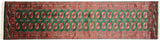 A top-down view of a vintage Bokhara runner's full, even pile height.