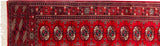 Corner view of a vintage Bokhara rug's fine weave, side selvage, and intact ivory fringe.