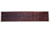 Vintage Bokhara rug runner with repeating rust and ivory gul medallions on a navy blue field.