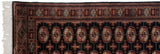 Bokhara rug white fringe, patterned side selvage, and terra cotta gul medallions.
