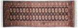 Bokhara runner corner, white fringe, plush black field, terra cotta elephant footprint guls.