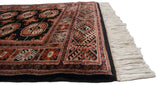 Ivory fringe and terra cotta, black, ivory geometric side border of the Bokhara runner.