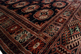Vintage Bokhara runner with intricate terra cotta, black, ivory, and green geometric patterns.
