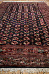 Full perspective view of the vintage Bokhara carpet, detailing its repeating gul pattern and fringed end border.
