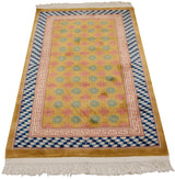 Vintage Art Deco rug corner with blush running-T and blue stacked cube geometric borders.