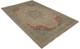 Angled view of a vintage Bulgarian carpet with a Kerman design medallion and floral border.
