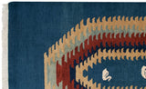 Qashqai design rug corner: deep blue, wine red, tan geometric pattern, white fringe.